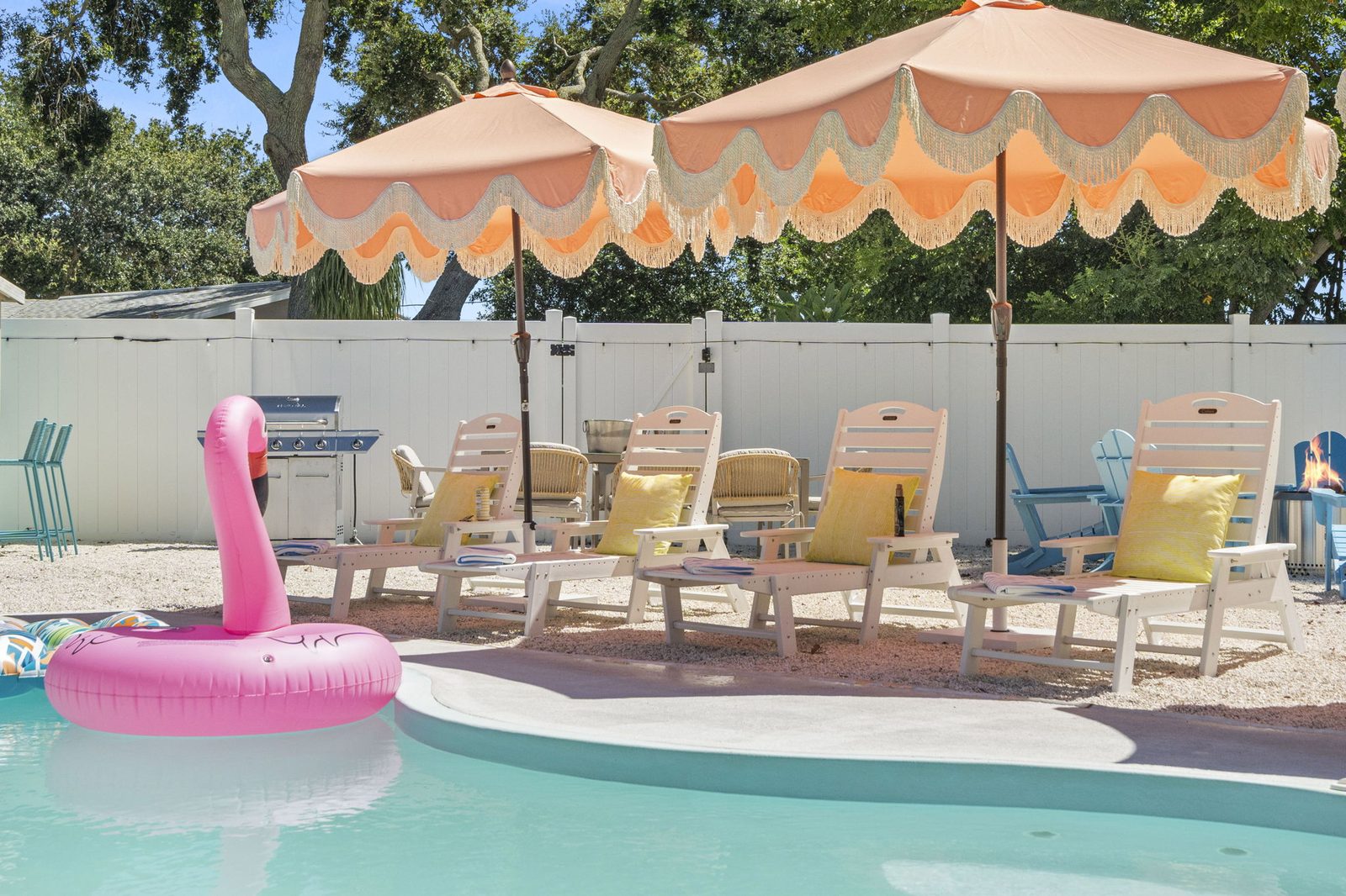 Pool deck with scalloped umbrellas and loungers on a sunny day at Palm Paradise